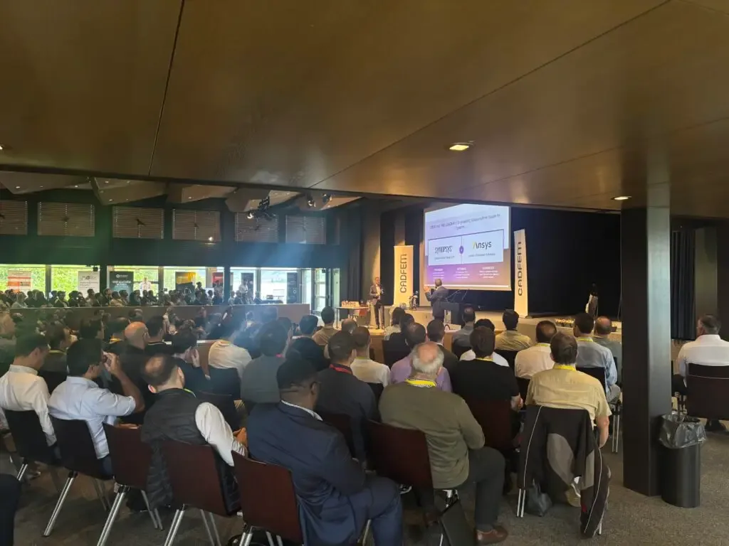 Packed conference hall at the CADFEM Conference Rapperswil with an audience watching a presentation on stage