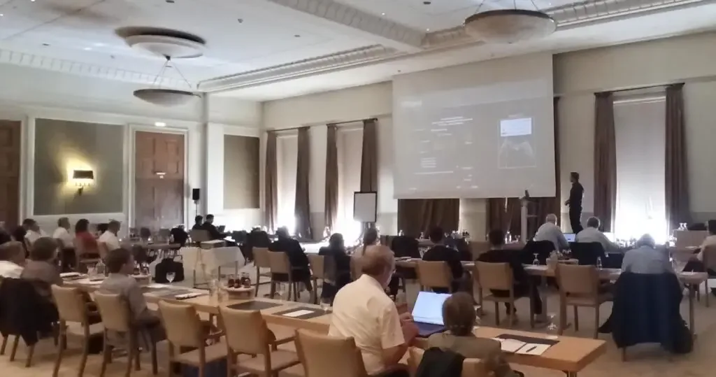 Conference room at Lacktagung 2025 with the audience following a presentation projected on a large screen