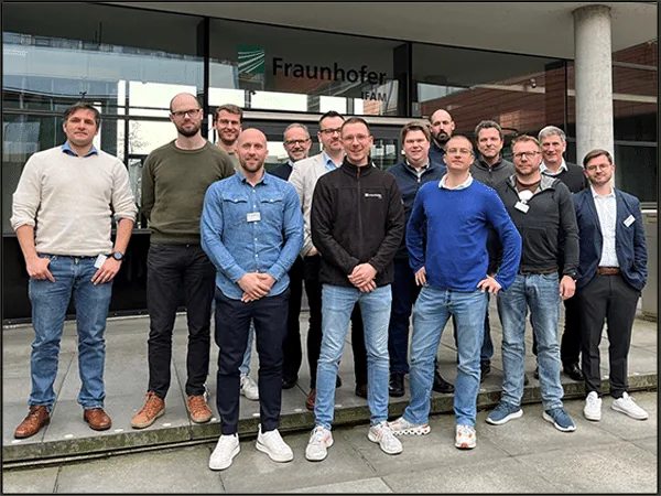 Fourteen members of the Na, Logisch project consortium standing in front of the Fraunhofer institute building in Bremen.