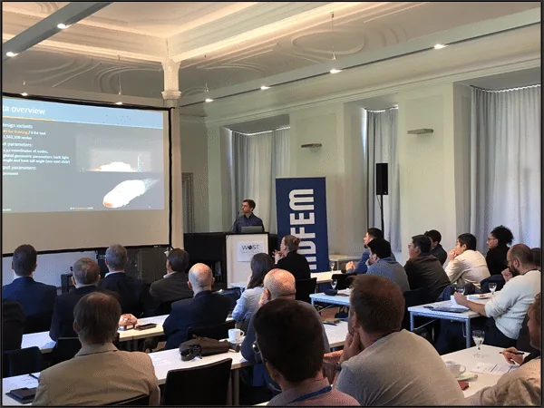 Conference room at WOST 2024 with a full audience watching a presentation slide showing a car aerodynamics dataset next to a CADFEM banner